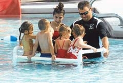 Water Safety Instructor/Lifeguard Shelby Hellen and ­Aquatics Supervisor Jason Sauer teach little ones at a Learn-to-Swim class at the Sapulpa Aquatics Center.