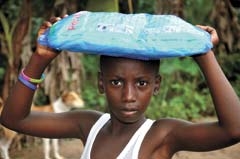 A Ghanaian boy receives a mosquito net, courtesy of Kairos10, that could very well save his life and the lives of family members.