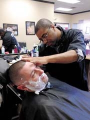Master Barber DeAllen Brown gives a client top-shelf ­treatment with a straight razor shave. Call DeAllen at (918) 734-1380 for an appointment.