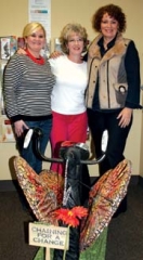 Brandi Moore, Rhonda Fletcher, and Jan McKay stand ­behind an art piece from the Art Bike Tulsa exhibit.