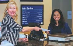 American Heritage Bank Assistant Vice President and Branch Manager Tami Fleak, left, welcomes Zarina George, the newest employee of the Tulsa branch, located at 71st and Union. Zarina performs double duty as bank teller and assists customers with their postal needs.