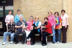 Lilac Festival committee members are making plans for their best festival yet. (Seated, L to R): Dave McFall, Dale Peterson with Pepper, who is sad because he is not eligible for the wiener dog derby, Nancy Fitts, Dell Davis with her wiener racer Jesse, 
Valerie Gunter with her wiener racer River, (Standing, L to R): Debi Ward, 
Carolyn Peterson, Cindy Bissett, Sue Cowan and Tanya Andrews.