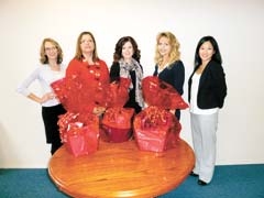 Lauren Wiehle, Lisa Prescott, Julie Kline, Maria Carter and Grace Claflin prepare gift baskets for door prizes at the Choices for Life foster parents appreciation dinner.