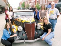 The Route 66 Blowout committee enjoys a look back in motoring ­history with this classic 1936 Ford convertible, owned by Larry ­Stansbury. (Clockwise from left): Sapulpa Main Street Executive ­Director Janet Beil, Gina Belk, Kayla Parnell, Larry Stansbury, ­Kristin Folger, Jessica Brose, Mike House and Cindy McDonald.