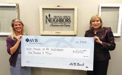 Kim Goddard, Broken Arrow Neighbors executive director, accepts a check from AVB Bank Chairman 
Kelley Rash for sponsorship of Wine, Eats and Easels.