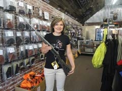 Becky Medlock holds the Ruger M77 Hawkeye Sporter 22-250 rifle that will be raffled off during the Elite Sports Express event, July 15 and 16 at ­Medlock Firearms in Collinsville.