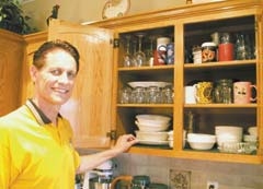 Gleam Guard owner Tracy Booth shows how a Jenks family left their kitchen ­cabinets before he applied Gleam Guard.