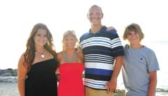 Planning a vacation is a good time to teach kids about managing money. Pictured: Steve Elliott with wife, Jenny, and their two kids, Kaylee and Cole, in Cozumel, Mexico.