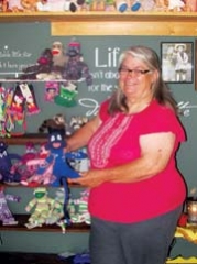 Carolyn Dormier displays one of the sports-themed sock monkeys at her shop, Country Grannie’s Playhouse in Inola. The sports-themed monkeys sell out fast, she says. Here she shows a sock monkey made from a Thunder sock. OU sock monkeys are her bestseller.