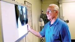 Examining a patient’s X-rays helps Dr. Mitchell determine the best course of action for treating pain.
