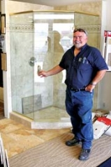 Tony Sementi, master craftsman and owner of Tile by Tony, opens the door to one of the tile showers on display at his showroom in Catoosa. Tile by Tony is more than just a tile store, specializing in kitchen and bath remodels.