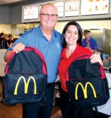McDonald’s of Owasso owner Tim Rich and General ­Manager Shannon McDonald display the backpacks that will be given to 250 area school-aged children at the ­back-to-school and Touch-a-Truck promotions.