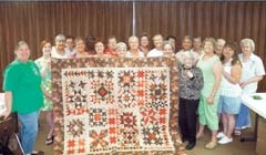 Scrap Happy Quilt Guild members hold the full-size Star Sampler quilt that will be raffled in a donation giveaway at the Quilt Show (L to R): (First Row) Francine Daniels, Ruby Bushyhead, (Second Row) Katie Goodman, Ann Danback, Carol Belter, Mary Waits, Laura Embrey, Emma Graham, (Third Row) MC Davis, Helen Matthews, Mickey Blitz, Katie Curtis, Pam Wadell, (Fourth Row) Fayne Parks, Iceola Dillingham, Frieda Daniels, Alice Bingman, Carolyn Haworth, Bettie Waters and Wanda Goodman.
