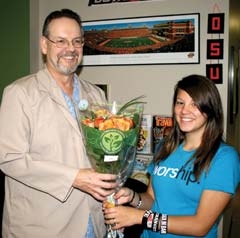 Haley, an appreciative young patient, presents 
Dr. Gene Woodard of Advantage Audiology with a bouquet of “OSU” orange roses for all his caring and assistance in helping her be able to hear.