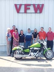 The Rogers County United Way Kickoff committee (L to R): Donna Ross (United Way), Mark Ogle (Red Cross), Mandi Bruner (J &amp; J Pharmacy and Gifts), Kim Timmermann (Amedysis), Mike Gatts (VFW Post Senior Commander), Delayna Trease (Summit Physical Therapy), Matt Streeter (RCB Bank), and Ryan Bradley (RSU). (Not pictured: Jared Trease, bike owner.)