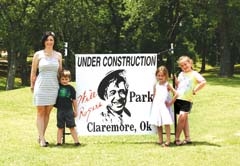 Crystal Campbell, with three of her four children - Luke, Addison and Cate, stand beside the banner announcing the construction of the Will Rogers Park Project, a plan to restore the five-acre park.