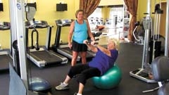 Personal trainer Tami Rice assists a client with her workout at Fitness Time for Ladies.