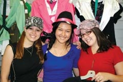 Students Kristin Payne and Sarah Luong enjoy hamming it up with Goodwill sales clerk Janet Saltarelli as they ­select fashionable back-to-school clothing for fall.