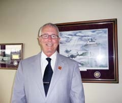 Dr. Larry Ellis stands in front of a photo he received from an appreciative patient while stationed in Germany.