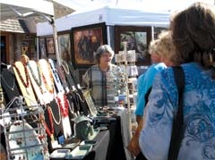 A jewelry artist talks to patrons at last year’s Art on Main.
