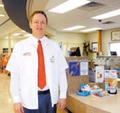 Greg Myers, pharmacist at Reasor’s at 71st and Sheridan in Tulsa, by the hearing loop system sign.