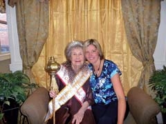 Patricia Fisher, donning her tiara and sashes while holding her queenly scepter, with Angela Crisp, activities director of Canoe Brook Assisted Living.