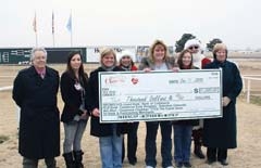 Members of the Claremore Chamber board presented a $10,000 check to last year’s
grand prize Santa Cash winner, Kim Massman, at Will Rogers Downs Grandstands. (L to R):&amp;#8200;Tony Cavallo and Ali Aguilar (Cherokee Casino Will Rogers Downs), Julie Adams, Pam Steffens, Kim Massman, Kelli Sellers, Santa Claus, and Dell Davis.