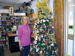 Employee Mary Kate Bollman shows off the selection of Old World Christmas 
ornaments available at J &amp; J.