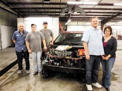 Randy and Liz Pruitt and staff members John Nash, Michael Minton and Jason Linzy stand with a vehicle damaged by a deer hit.