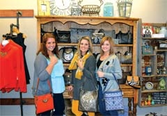 Ally Johnson, Karina Pope and Madison Todd show off 
some of the Brighton bags available for purchase at The District on Main in downtown Claremore.