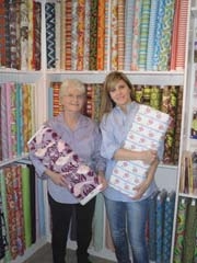 Mother-in-law and daughter-in-law team Jan and Tammy Bemies show off some of the fabrics available at Cotton Cottage in Claremore.