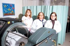 Tulsa Wound Care and Hyperbaric Center staff pictured with a  ­hyperbaric chamber: (L to R) Lori Ormsby, Director of the Wound Program; Kathy Kelley, HBO Supervisor; and Tricia Sheehy, Manager.