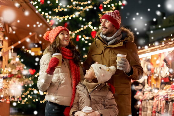 Couple enjoying hot chocolate at Christmas event.